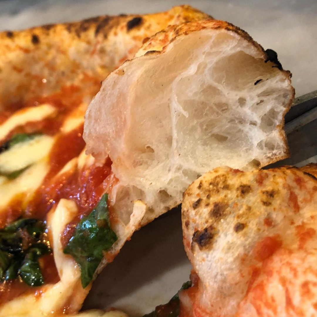 Perfect slice of wood-fired pizza served during Albuquerque sunset cooking class