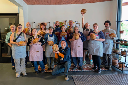 Team Building Activities in Albuquerque participants showcasing their handcrafted bread at a pizza-making workshop.
