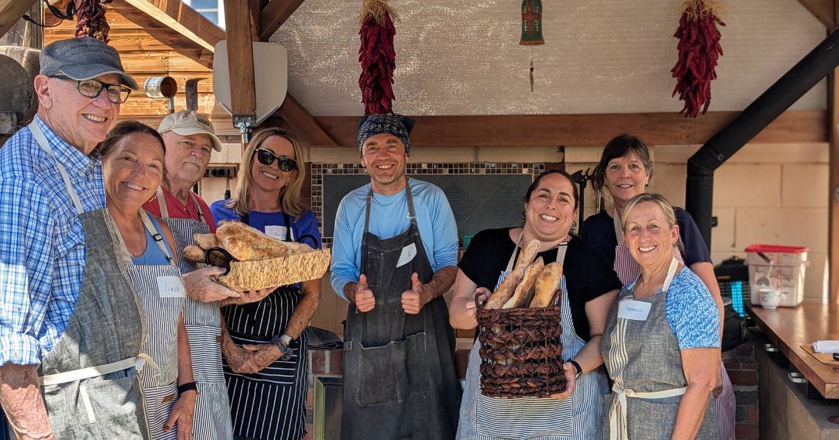 Happy students showing off fresh bread after a hands-on cooking class in Albuquerque