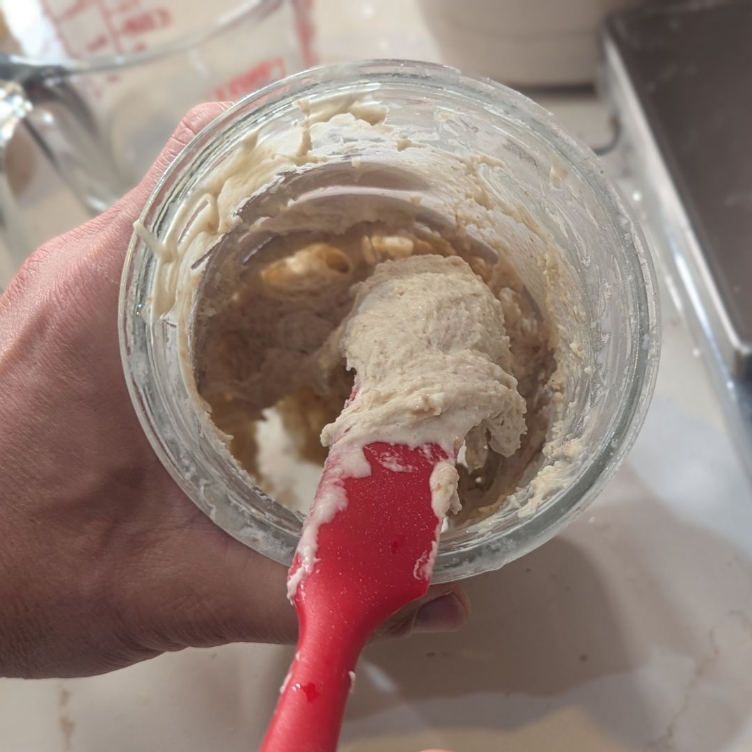 Jar of active sourdough starter with bubbles, ready for baking