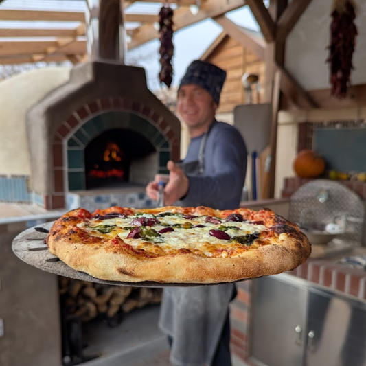 Pizza baking in a traditional wood-fired brick oven at high heat