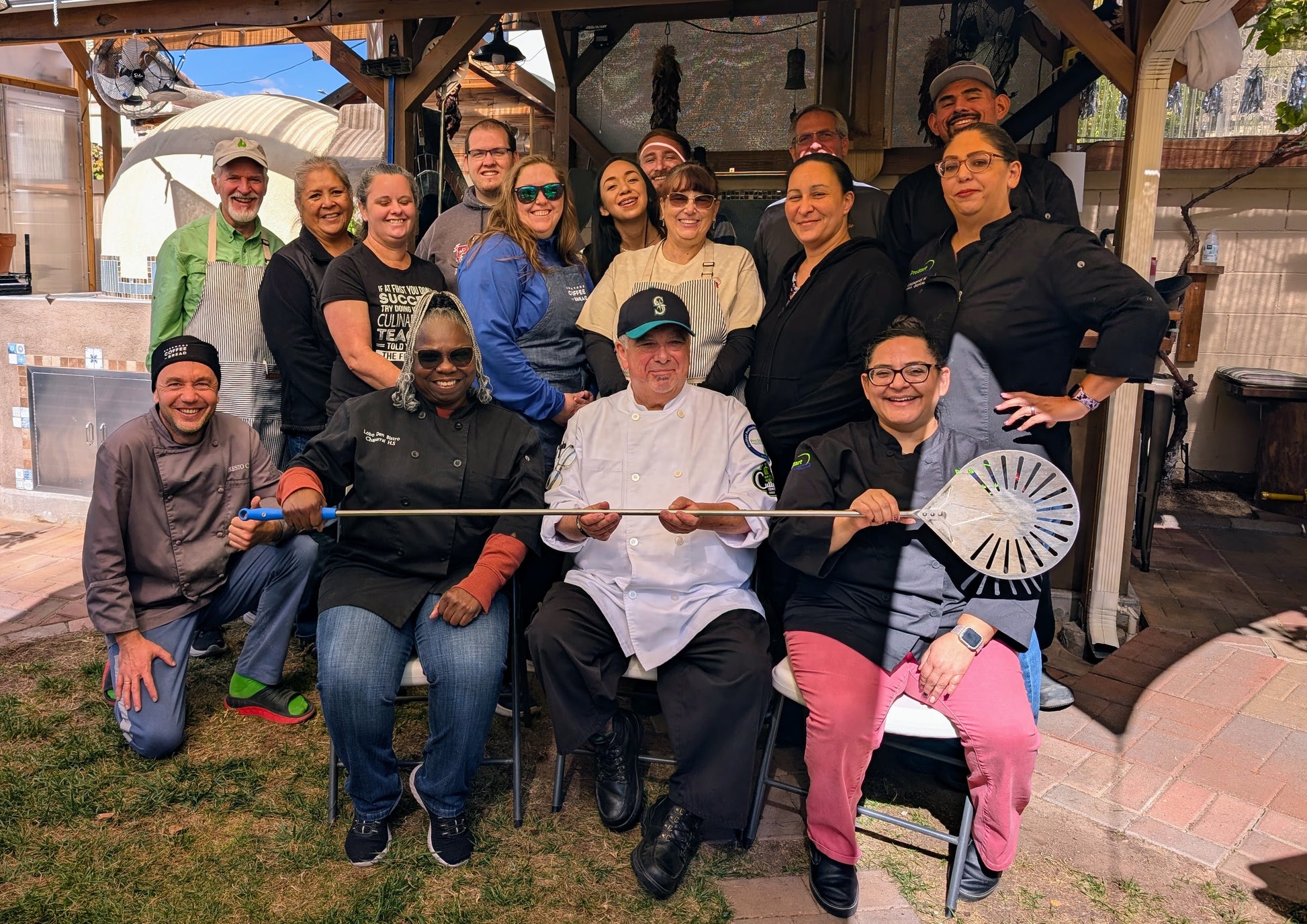 Team taking group photo after pizza cooking class in Albuquerque